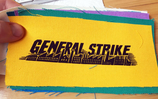 colorful patches printed with bold text and a backdrop of smokestacks