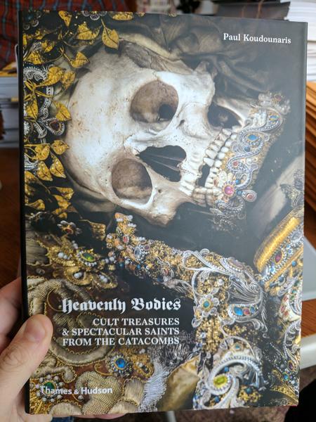 Heavenly Bodies: Cult Treasures & Spectacular Saints from the Catacombs by Paul Koudounaris (a photo of a gold and jewel encrusted skeleton with a crown of golden leaves)