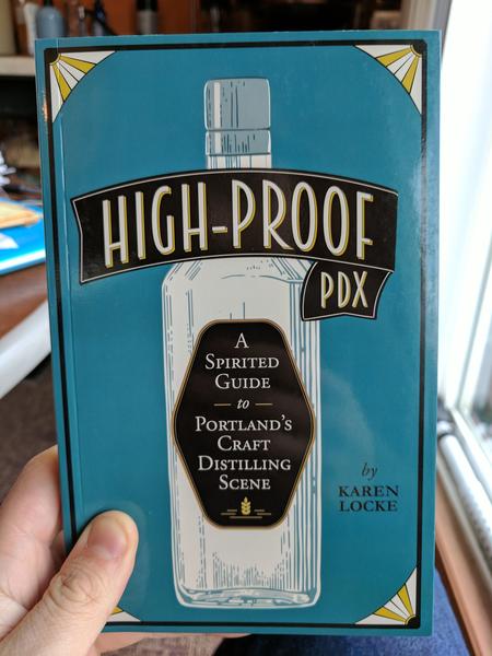 High-Proof PDX: A Spirited Guide to Portland's Craft Distilling Scene by Karen Locke (a blue background with gold and white corners. The title is sealed on a tall, glass bottle)