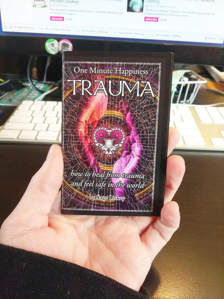 Cover of Trauma: How To Heal From Trauma And Feel Safe In The World (One Minute Happiness) which features two glowing purple/orange hands cupping a heart and chalice floating between them.