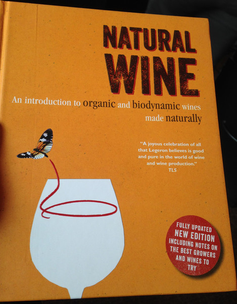 Second edition book is orange with image of a butterfly flying out of a wine glass. 