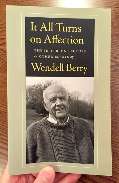 a black and white photo of wendell berry standing in a field
