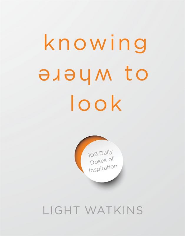 a white cover with orange text and a hole punched in the middle of the cover with the piece of white dangling, partly obscuring the orange behind