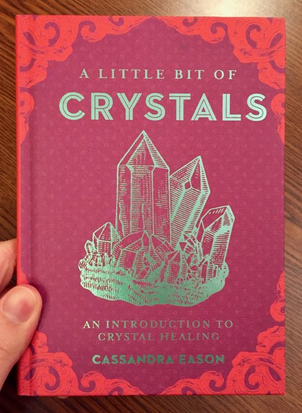A Little Bit of Crystals: An Introduction to Crystal Healing [A teal crystal shard on a maroon background.]