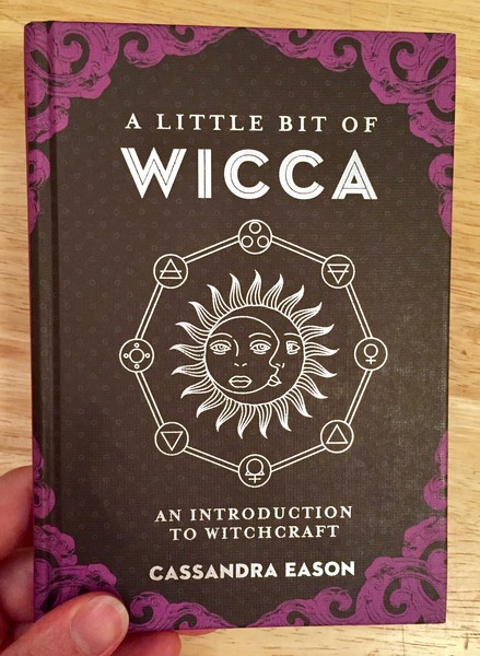 A Little Bit of Wicca: An Introduction to Witchcraft by Cassandra Eason [the cover features a sun and moon intertwined surrounded by 8 symbols representing the sabbats]