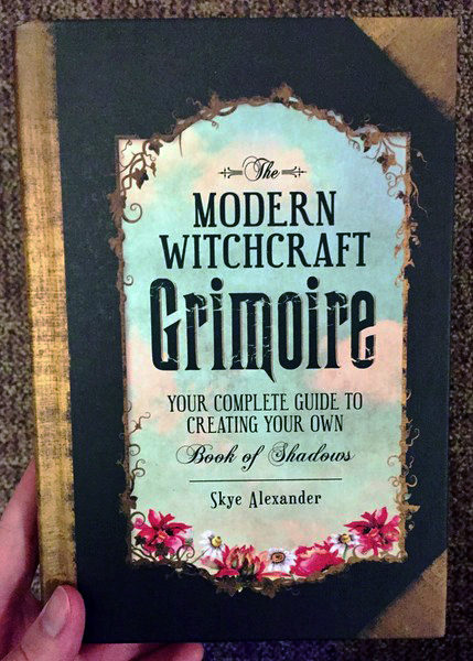 Cover of The Modern Witchcraft Grimoire: Your Complete Guide to Creating Your Own Book of Shadows which features a border of flowers and greenery around the title