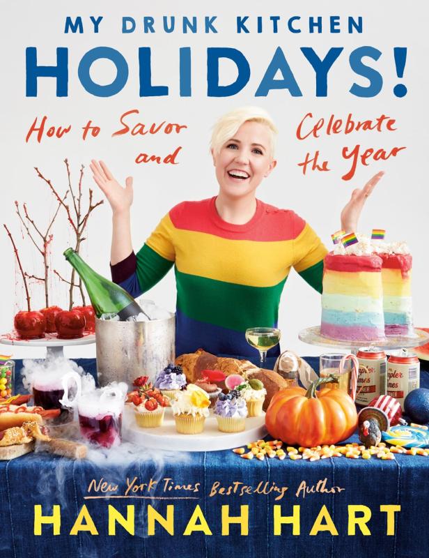 A lady stands at a table covered in colorful holiday treats.