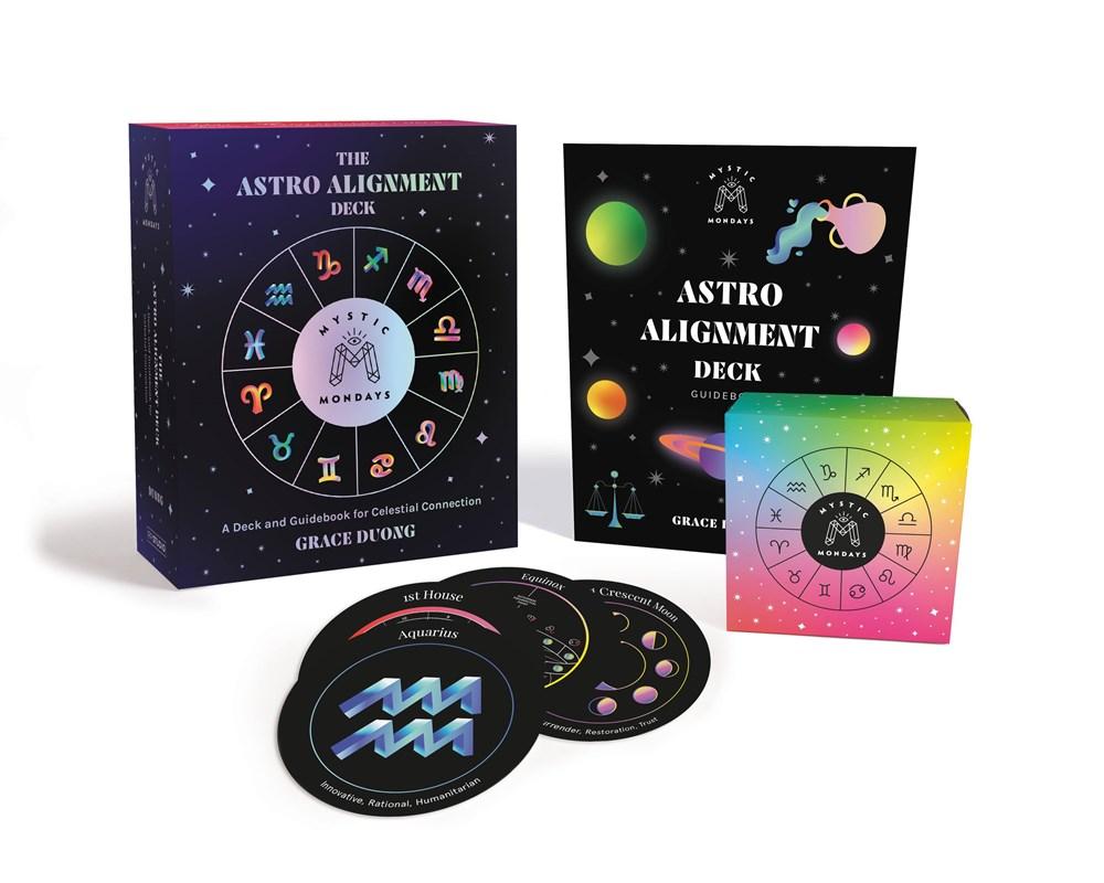 all of the astrological symbols illustrated on the deck box in a circle around a reflective logo for Mystic Mondays made up of crystals in the shape of an M