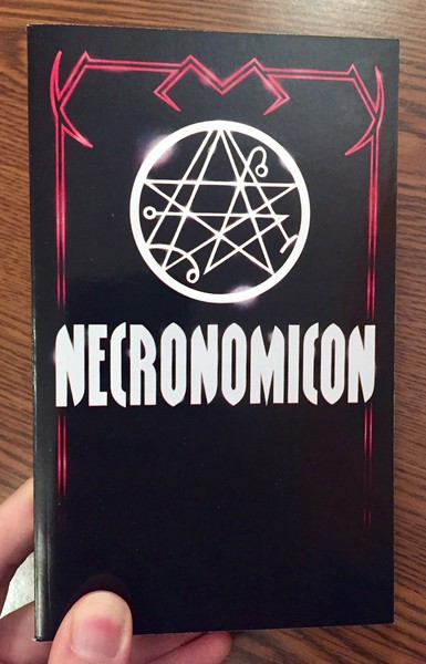 a black paperback with some satanic symbolism