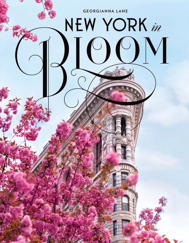 the flatiron building with a blooming tree in the foreground