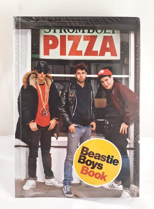 The Beastie Boys standing in front of a pizza restaurant. 