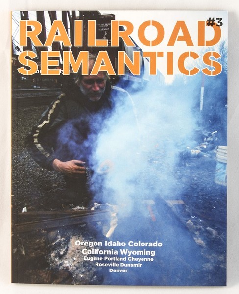 a photo of someone starting a fire by railroad tracks