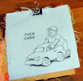 patch with image of a man and a car with the text "fuck cars"