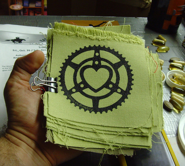 canvas patch printed with the microcosm logo a bicycle chainring heart