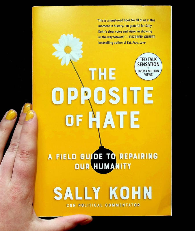 Bright yellow cover with a daisy growing out of a bomb and the book's title, "The Opposite of Hate: A Field Guide For Repairing Our Humanity"