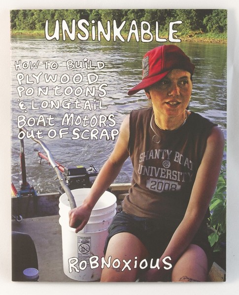 A book with a photo of a person steering a hand-made boat on a river