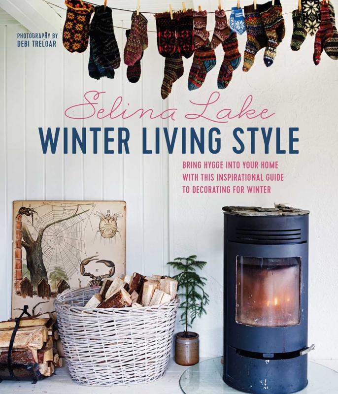 A photo of a wood stove, socks drying above, against a white washed wall 