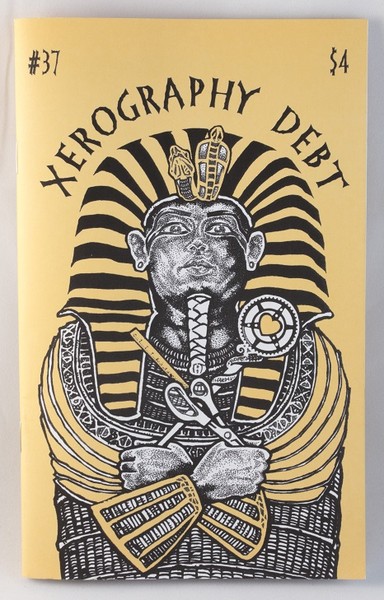A yellow zine with a black and white illustration of an Egyptian sarcophagus clutching scissors, a ruler, and a microcosm wand